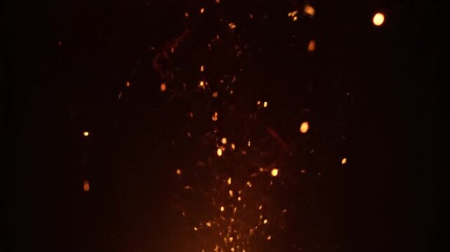Abstract glowing particles rising against black background bokeh effect