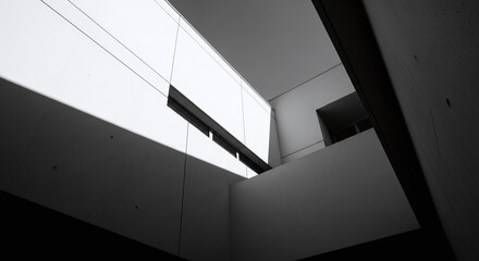 Fototapeta premium Black and white photo of a modern buildings interior corner with a skylight.