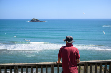 Fototapeta premium Tourist looking at the gannets flying at Muriwai Beach. Auckland.