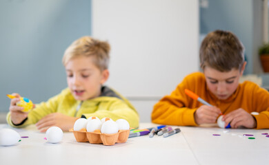 Naklejka premium Children decorating eggs for easter festivities at home