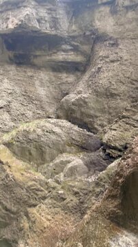  water dripping from the steep rocky walls of partnach gorge while a fast mountain river flows below. early spring atmosphere with melting snow, cold water and dramatic alpine nature in garmisch-parte