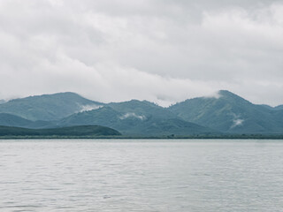 Gentle reflections of lush mountains on placid lakeside surface