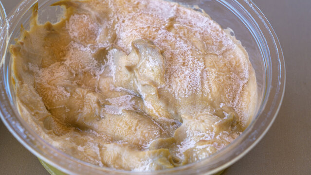 MACRO, DOF: White layer of mold forms on the top of a jarred tahini paste.