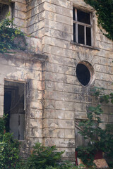 An old, ruined railway station building covered in ivy in Old Gagra.