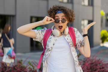 Oh my God, Wow. Happy young man taking off sunglasses looking surprised at camera with big open...