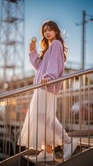Young woman in purple knitwear enjoying ice cream at golden hour