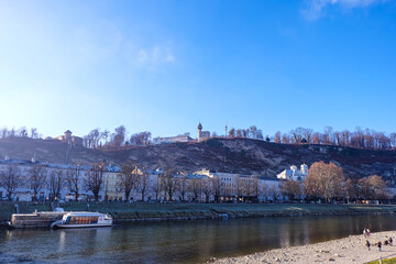 Fototapeta premium The old town of Salzburg, viewed over the Salzach river on a beautitul blue sunny sky winter day 