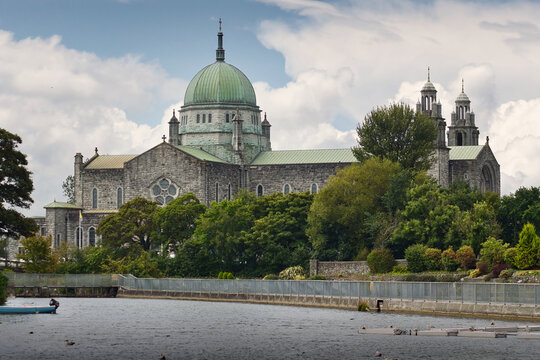 Galway Cathedral of Our Lady Assumed into Heaven and St Nicholas by River Corrib under Cloudy Sky in Galway City, Ireland, travel landmark architecture