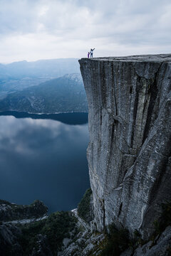 Randonneur au sommet de Preikestolen dominant le Lysefjord en Norv&egrave;ge