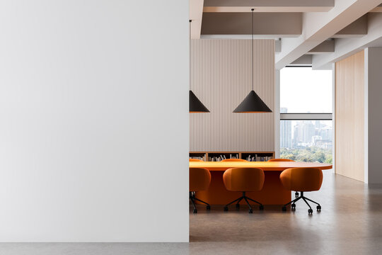 Modern office interior with blank white wall and stylish orange furniture in front of city view windows and wooden panel accent wall background. 3D Rendering