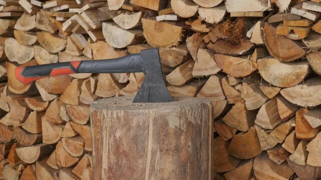 Hands driving an axe into a wooden chopping block for wood preparation