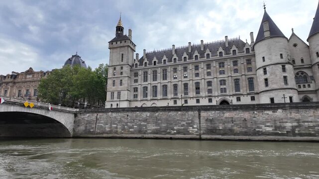 Conciergerie and pont au change on seine river in paris, france seen from bateau mouche tourist boat navigating historic ile de la cite during sightseeing tour