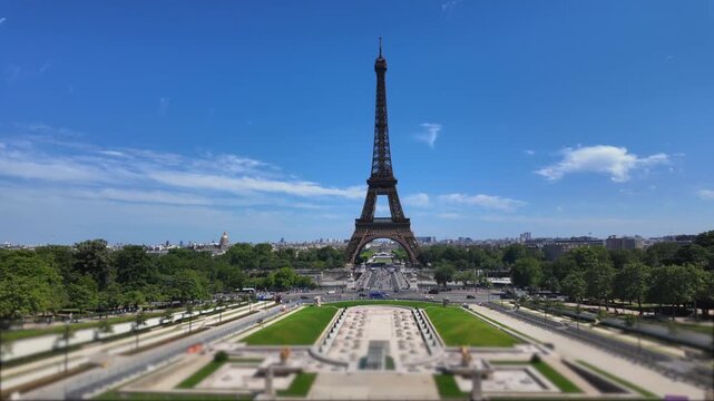 Iconic eiffel tower standing tall in paris on a sunny day with tilt-shift effect, showing the trocad&eacute;ro gardens and bustling city traffic in the background