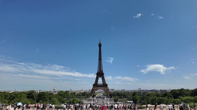Eiffel tower landmark standing tall in paris on a bright sunny day with tourists walking, creating a beautiful cityscape of the french capital viewed from the trocadero