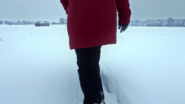Spaziergang in trister schneeverh&uuml;llter Winterlandschaft: Frau in dicker Jacke stapft durch den Schnee im kalten Winterwetter, Jahreszeit, wandern, frostig, Weite, Ruhe
