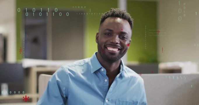 Smiling developer sitting in office cubicle, initiating drifting red glyphs, binary digits swirling