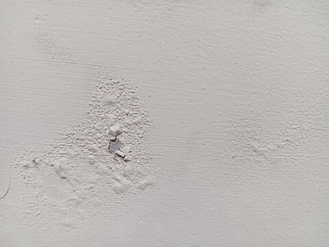 Close up of abstract texture blistering and peeling paint on  white wall surface.