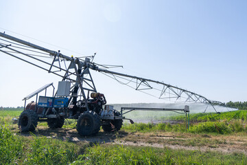 Fototapeta premium Autonomous machine is moving watering pivot along irrigation canal