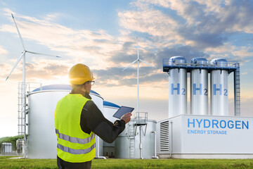 Engineer with tablet computer on a background of Green Hydrogen factory