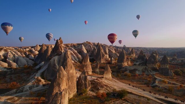 Aerial view Landscape sunset in Cappadocia, travel tour excursion on horse with hot air balloons in Goreme Turkey.
