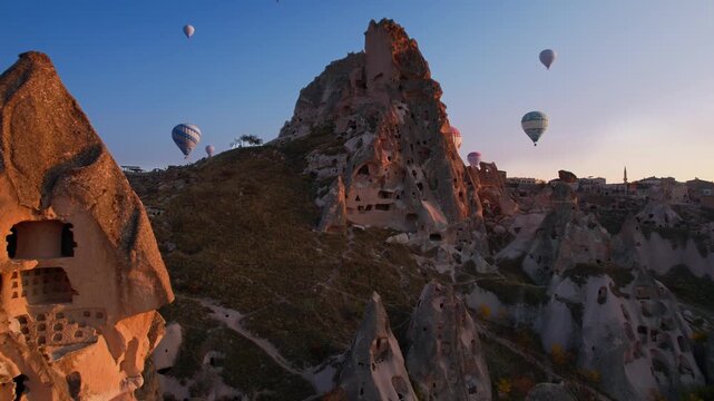 Hot air balloons over Ancient Uchisar castle, underground city of Cappadocia Turkey, Aerial view Goreme national park.