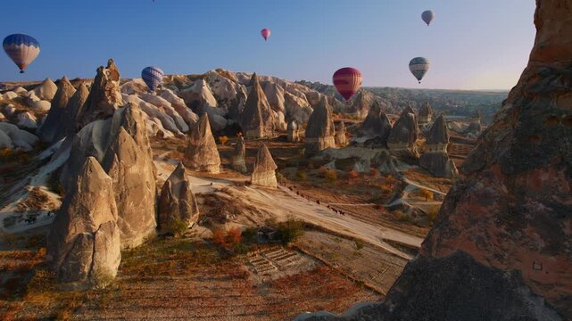 Travel tour excursion on horse with hot air balloons in Cappadocia, Goreme Turkey, Aerial view sunset time.