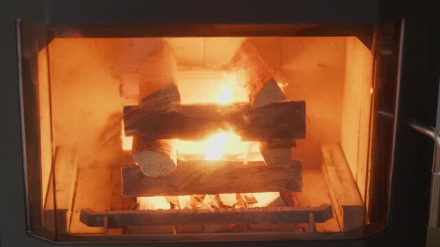 Flickering flames of a newly lit fire in a fireplace, initial combustion of wood logs