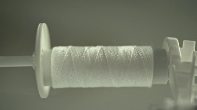 An automatic sewing machine efficiently transfers thread from a large spool to a smaller skein, expertly rewinding it for future sewing operations, serving the precise needs of fabric manipulation