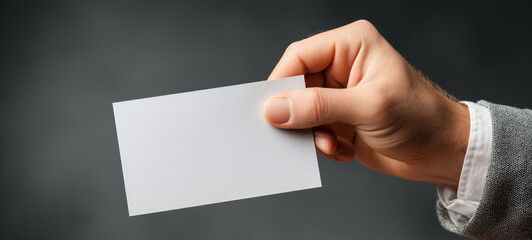 Obraz premium Close Up of Hand Holding Blank White Business Card , Minimal Corporate Mockup for Branding, Identity, Marketing, Contact Information and Professional Presentation with Copy Space