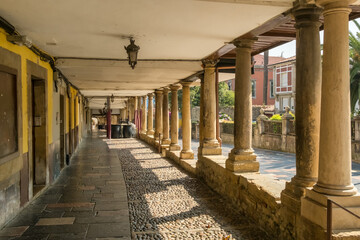 Naklejka premium Historic Stone Columns and Cobblestone Pedestrian Passage in Aviles