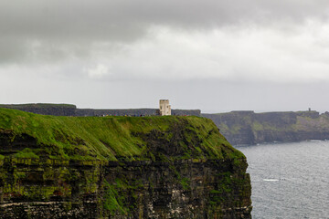 a rainy and stormy summer day at the famous cliffs of moher in the irish County Clare. A View to the famous O'Briens tower next to the cliffs. 