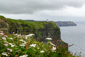 a rainy and stormy summer day at the famous cliffs of moher in the irish County Clare. A View to the famous O'Briens tower next to the cliffs. 