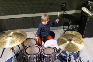 Obraz premium Young boy practicing drums, developing musical talent
