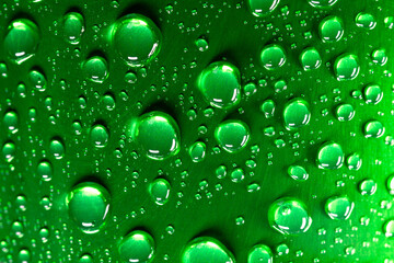 Water droplets on a green surface with light reflections