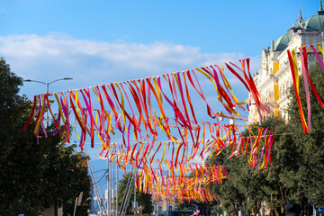 Long rows of colorful ribbons decorating a city boulevard in Rijeka during carnival time. Festive urban scenery representing movement