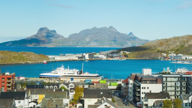 Bodo, Norway. View of the marina in the city center of Bodo, Norway with a fjord and a mountain in the background. Time-lapse during a sunny winter day, zoom in