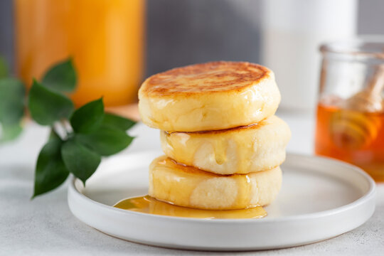 Syrniki, cottage cheese fritters on grey plate. Made with curd or cottage cheese these fried cheese pancakes are soft, delicious and rich in Protein and Calcium. Healthy food