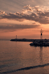 Molo e faro di Skopelos al tramonto dalla spiaggia vicina al porto