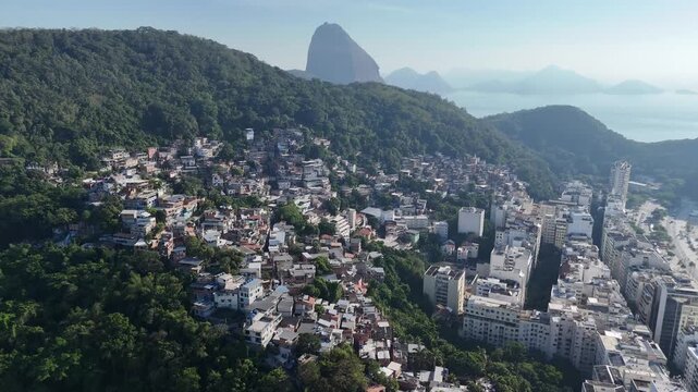 Drone flyover of Babil&ocirc;nia favela with Sugarloaf Mountain, Rio de Janeiro (fast)