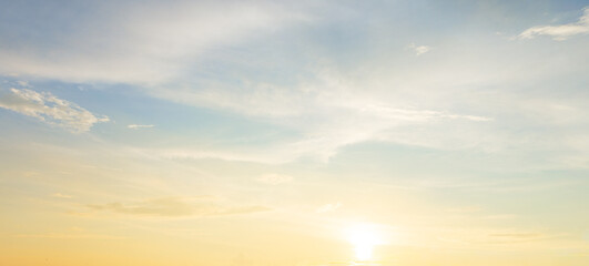 Obraz premium Beautiful sunset sky with soft orange and purple clouds background,Panoramic view of dramatic evening sky during sunset. Vibrant orange light on the horizon blending with soft purple and blue tones.