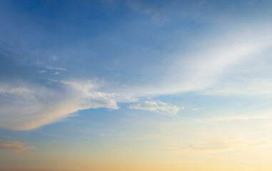 Fototapeta premium Beautiful sunset sky with soft orange and purple clouds background,Panoramic view of dramatic evening sky during sunset. Vibrant orange light on the horizon blending with soft purple and blue tones.