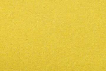 Obraz premium Top view of textured yellow paper background for design,macro,A high-resolution, close-up shot of a vibrant yellow paper texture. The surface features a subtle, grainy fiber detail, making it ideal.
