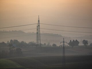 Strommasten einer &Uuml;berlandleitung im Abenddunst