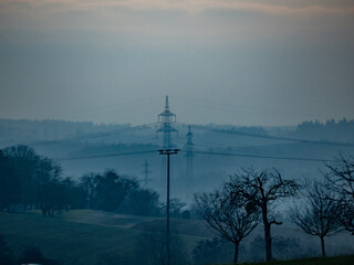 Strommasten einer &Uuml;berlandleitung im Abenddunst