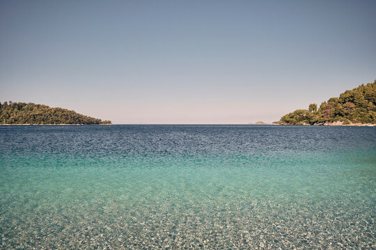 Mare turchese cristallino a Skopelos con colline boscose sullo sfondo