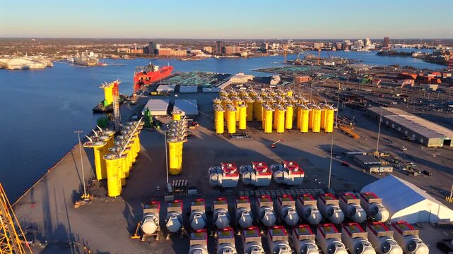 Aerial view of wind turbine nacelles and yellow transition pieces arranged at port terminal