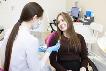 Obraz premium A dentist shows a woman how to brush her teeth