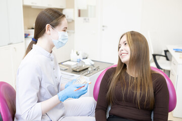 Fototapeta premium A dentist shows a woman how to brush her teeth