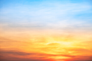 Obraz premium Sunset or sunrise sky with a vibrant gradient of orange, gold, and soft blue. Clear atmosphere with wispy clouds. Peaceful, natural light background. hope, freedom, new day and inspirational Concepts