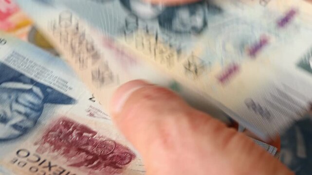 Mexico peso. A large amount of cash. A man is counting Mexican money in his hand. Financial concept. Business background. Close up